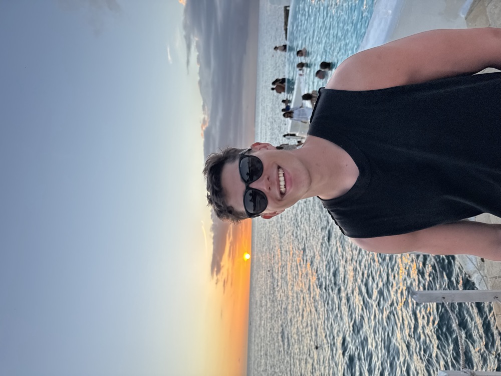 Nicolás Villanueva sonriendo frente al mar al atardecer